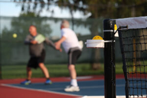 A doubles pickleball team is at the net attempting to win a point