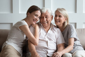 Happy three-generation family hugging sit on sofa enjoy time together at home,