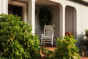 Veranda with a rocking chair among the greenery of the garden.